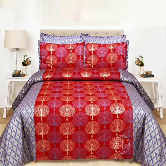 Red and blue patterned bedspread on a bed with matching pillows in a bedroom setting.