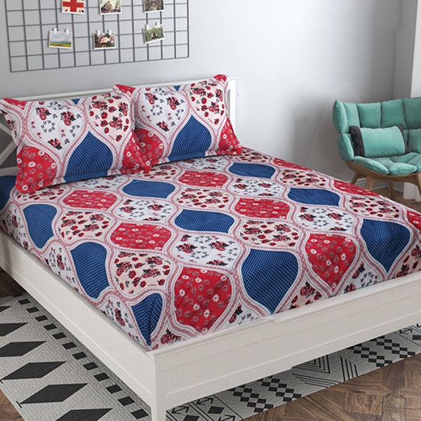 Bed with red, blue, and white geometric patterned bedding in a room.
