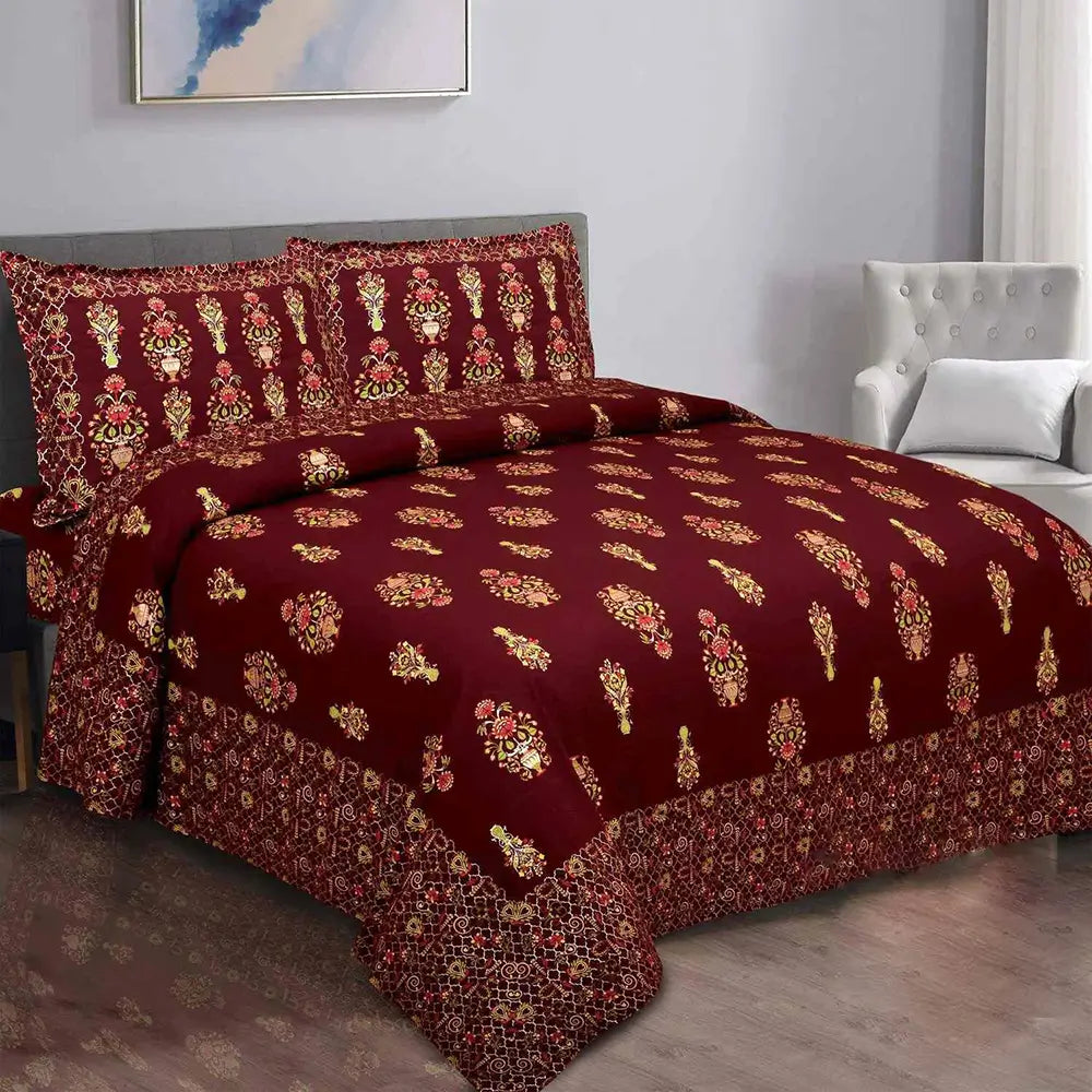 Maroon floral patterned bedsheet on bed with a gray headboard.