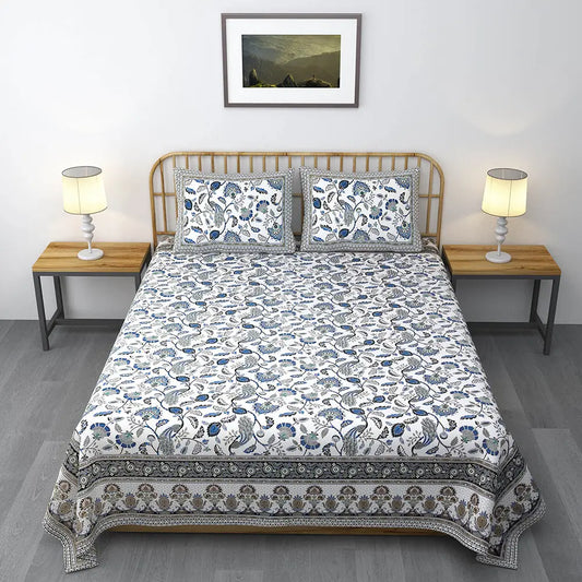 Bed with floral patterned bedding in a bedroom setting Blue Floral Peacock White Base Jaipuri Gold Print Bedsheet
