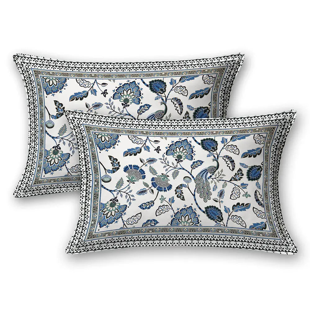 Two floral patterned pillows wit Jaipuri gold bedsheet on a white background