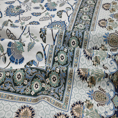 Close-up of jaipuri gold bedsheet patterned fabric with floral and paisley designs in blue, green, and beige.