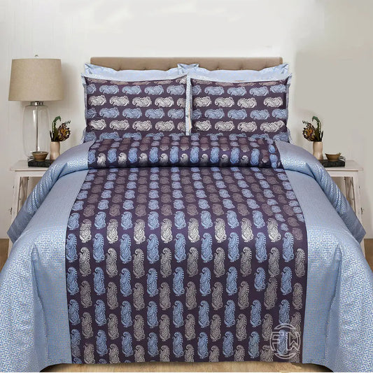 Bed with blue and purple patterned bedding set in a bedroom setting.