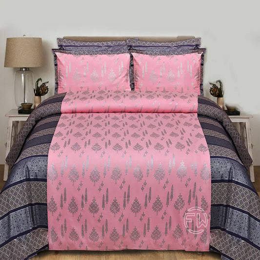 Pink and gray patterned bedding set on a bed with a lamp and nightstand in the background.