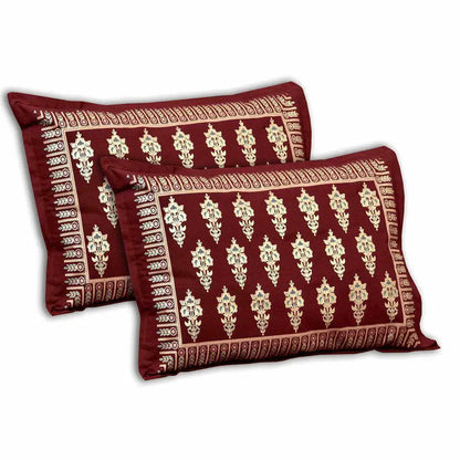 Two red pillows with gold patterns on a white background with bedsheet