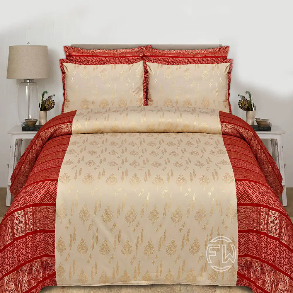 Red and beige patterned bedspread on a bed with matching pillows, in a bedroom setting.