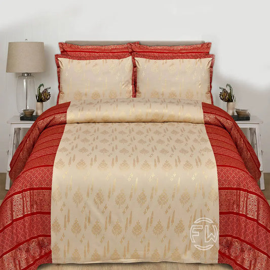 Red and beige patterned bedspread on a bed with matching pillows, in a bedroom setting.