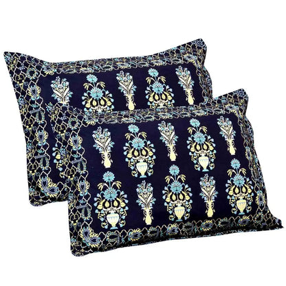 Two decorative pillows with floral patterns on a navy background with bedsheet